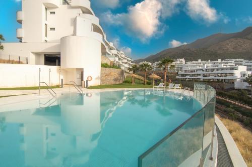 una piscina con vista su un edificio di Mara's Apartments Higueron West - Scandinavian Luxury - Views of the Sea and Natural Landscapes a Fuengirola