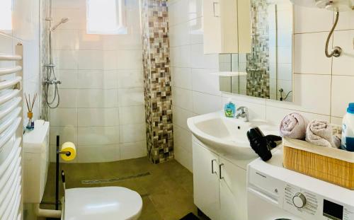 y baño con lavabo, aseo y espejo. en zentrale,vollausgestattete Ferienwohnung - 3 Zimmer, Petrovic, en Kapfenberg