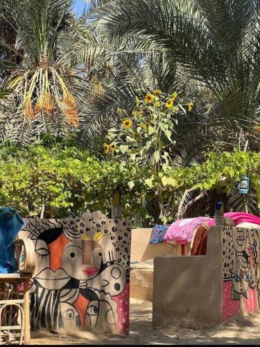 a wall with graffiti on it next to a table at كامب طموسي in Siwa