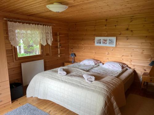 a bedroom with a bed in a wooden cabin at Cottage Stranden in Kruunupyy