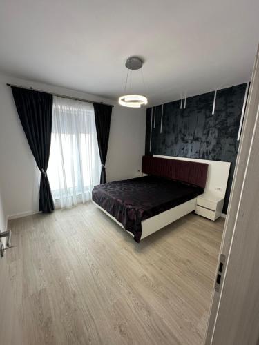 Un dormitorio con una cama y una ventana grande en GlamArt Apartment, en Craiova