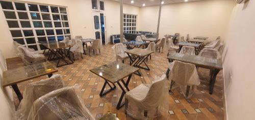 una habitación vacía con mesas y sillas en bolsas de plástico en Raahi Hotel City Site Gilgit, en Gilgit