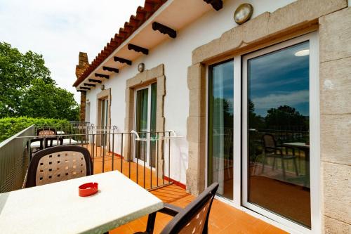 a patio with a table and chairs on a balcony at Hotel Castell Blanc in Empuriabrava