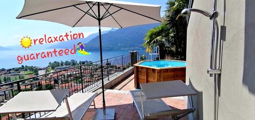 a balcony with an umbrella and a swimming pool at Sole & Lago-Lake in Maccagno con Pino e Veddasca