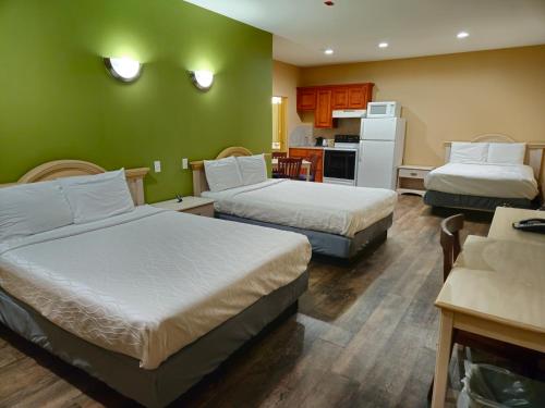 a hotel room with two beds and a kitchen at Weston Inn & Suites in Rusk