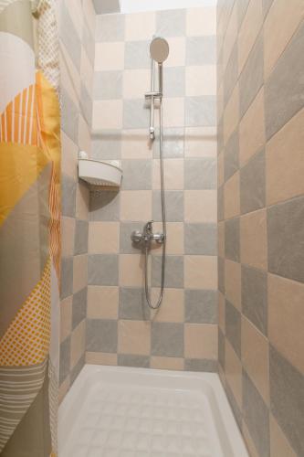 a bathroom with a shower with a tiled wall at Villa Filyra in Kato Gatzea