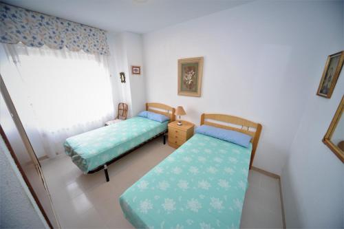 1 Schlafzimmer mit 2 Betten und einem Fenster in der Unterkunft CUMBREMAR Orangecosta in Benicàssim