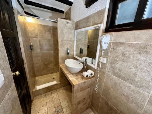 een badkamer met een wastafel en een spiegel bij Hatun Inti Classic in Machu Picchu