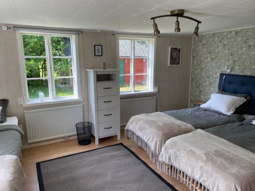 1 dormitorio con 2 camas, vestidor y ventanas en Martebo Bed & Breakfast en Tingstäde