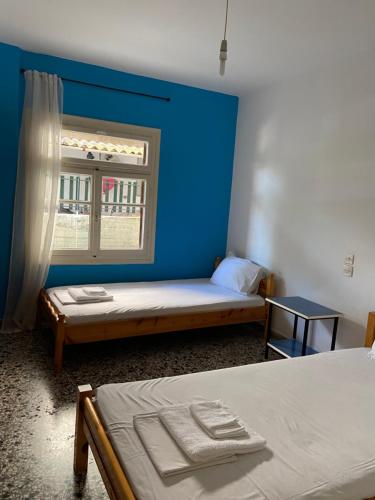 Cette chambre comprend 2 lits et un mur bleu. dans l'établissement Family apartment with 2 bedrooms to the city center, à Kamena Vourla