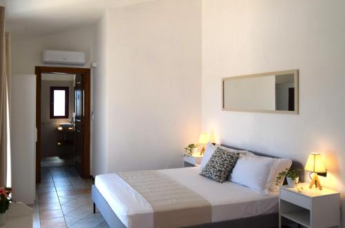 a white bedroom with a bed and two night stands at La Terrazza in Olbia
