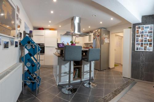 a kitchen with a counter with blue chairs in it at #2 Großes Zimmer mit Pool und Garten in Memmingen