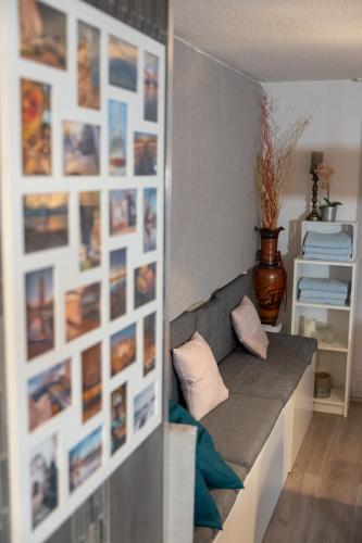 a room with a couch and a wall with pictures at #2 Großes Zimmer mit Pool und Garten in Memmingen