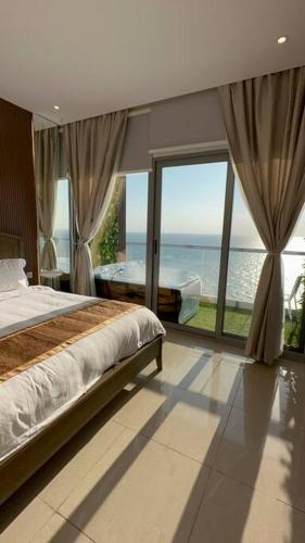 a bedroom with a bed and a view of the ocean at برج داماك الجوهرة جدة , الجناح الذهبي-Damac jawharah tower in Jeddah