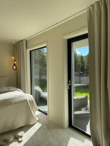 een slaapkamer met een deur naar een patio met een bed bij Lekkert rekkehus med peis in Hektner