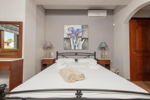 a bedroom with a bed with towels on it at Villa Filyra in Kato Gatzea