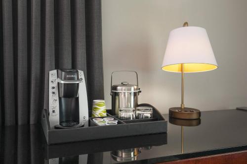 a tray with a coffee maker and a lamp on a table at Le Meridien Boston Cambridge in Cambridge