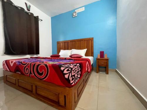 um quarto com uma cama com um cobertor vermelho e branco em Mountain cheers munnar em Munnar