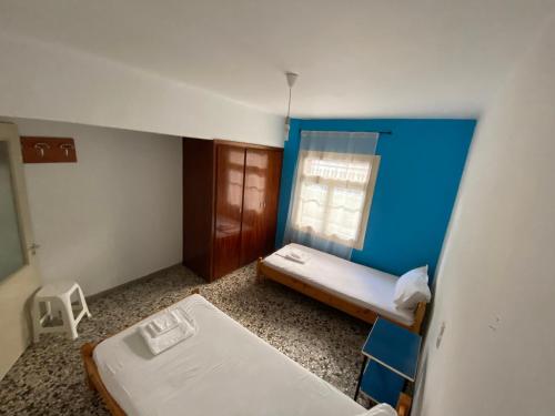 a small room with two beds and a blue wall at Family apartment with 2 bedrooms to the city center in Kamena Vourla