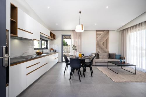 a kitchen and living room with a table and chairs at Campo Premium Stay Private Pool Villas in Kos