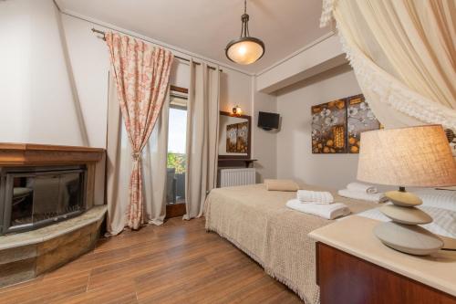 1 dormitorio con 1 cama y chimenea en Villa Fylira, en Kato Gatzea