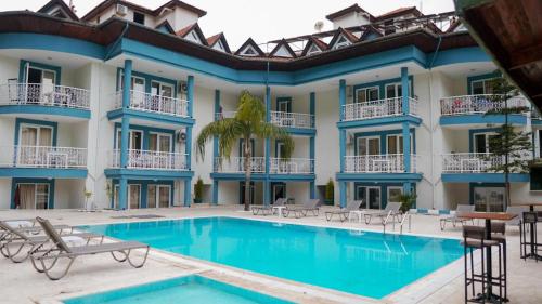 a hotel with a swimming pool in front of a building at EGE APART HOTEL in Marmaris