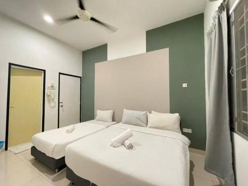 a bedroom with two beds and a ceiling fan at Cozy 119 Homestay Teluk Intan in Teluk Intan