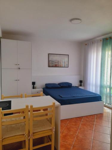 een slaapkamer met een bed en een tafel en stoelen bij Seaside Deluxe Apartment in Durrës