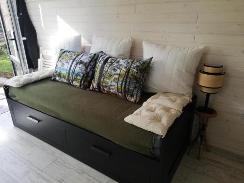 un lit avec des oreillers dessus dans une chambre dans l'établissement Petite maison de vacances, à Onesse-et-Laharie