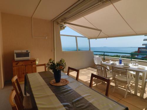 une salle à manger avec une table et un balcon dans l'établissement Spacieux 34m² avec clim, WIFI, loggia et terrasse pour 6 pers à Sète - FR-1-472A-182, à Sète