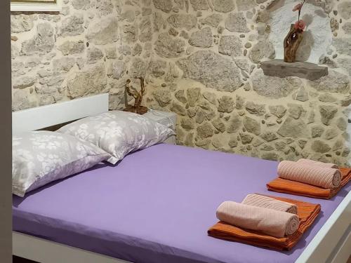 Una cama con dos toallas encima. en Holiday home Leptir, en Siverić