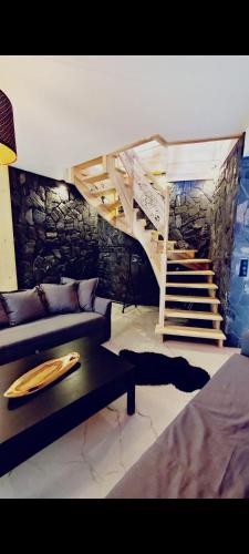 a living room with a staircase and a couch at Wood House in Nowy Targ