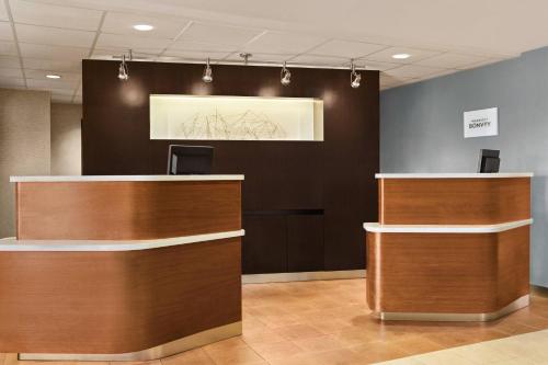 an office lobby with a reception desk and a painting on the wall at Courtyard by Marriott Roseville in Roseville