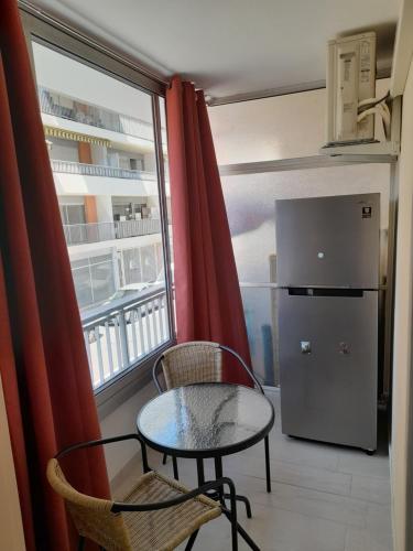 Cette chambre dispose d'une petite table et de chaises. dans l'établissement F1 à 5 minutes des plages et de la gare, à Vallauris