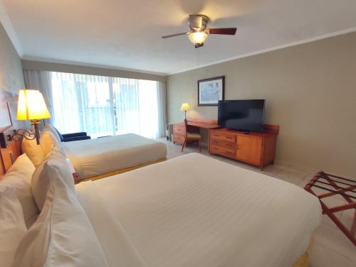 Cette chambre comprend deux lits et une télévision. dans l'établissement Ixtapan de la Sal Marriott Hotel & Spa, à Ixtapan de la Sal