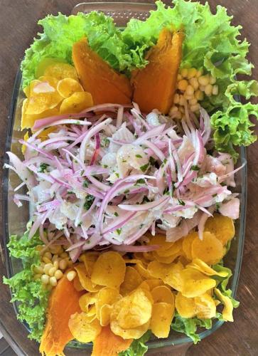 a plate of food with a salad and vegetables at Hospedaje & Casa Playa AURORA in Zorritos