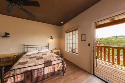 a bedroom with a bed and a balcony at Miners Cabin #2 - One Queen Bed - Accessible Room - Private Balcony in Tombstone