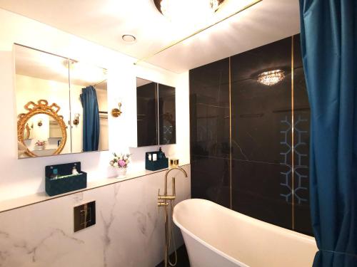 a bathroom with a bath tub and a mirror at Luxury Penthouse with Large Terrace & Panoramic Old Town View in Vilnius