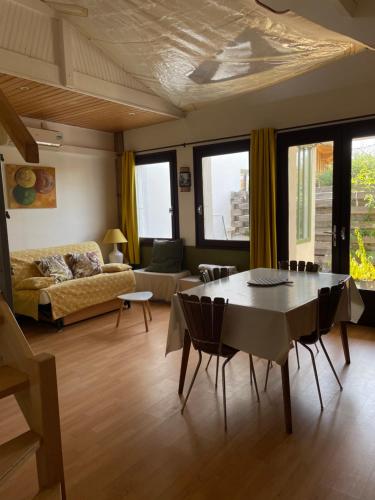 un salon avec une table et un canapé dans l'établissement JOLI APPARTEMENT AVEC JARDIN, à La Teste-de-Buch