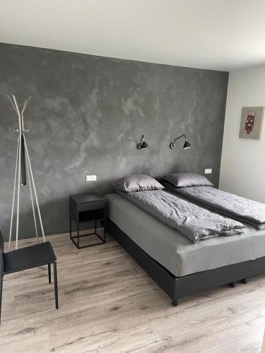 a bedroom with a large bed with a gray wall at Saga Apartments Reykjavík in Reykjavík
