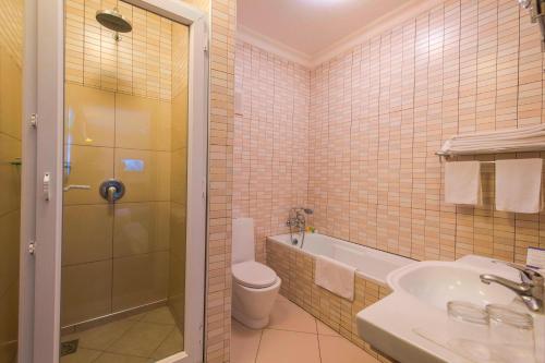 uma casa de banho com um WC, um lavatório e um chuveiro em Protea Hotel by Marriott Dar es Salaam Courtyard em Dar es Salaam