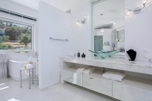 a white bathroom with a tub and a sink at Dion Villa Zakynthos Greece in Zakynthos