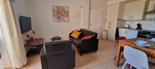 a living room with a couch and a kitchen at Casa Rebecca, apartment with a poolview in Murcia