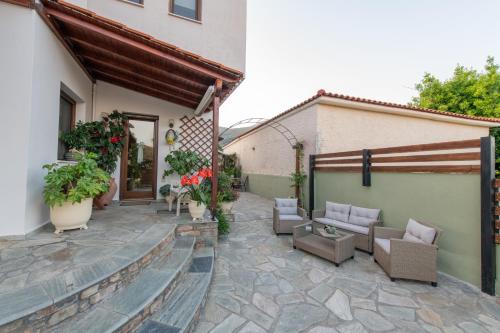 a patio with furniture and flowers in a building at Villa Filyra in Kato Gatzea