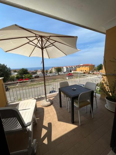 a patio with a table and an umbrella at Residenza De Luca Apartment in Tropea