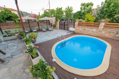 a swimming pool in a backyard with a wooden deck at Villa Filyra in Kato Gatzea