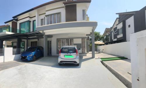 ein Auto, das auf einem Parkplatz vor einem Haus parkt in der Unterkunft Patience Homestay Kuala Selangor in Kuala Selangor