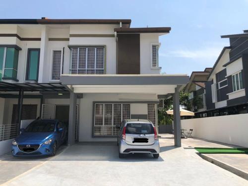 due auto parcheggiate davanti a una casa di Patience Homestay Kuala Selangor a Kuala Selangor
