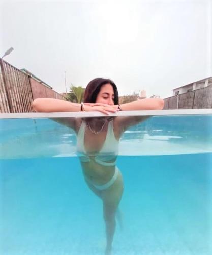 a woman is standing in a swimming pool at Hospedaje & Casa Playa AURORA in Zorritos