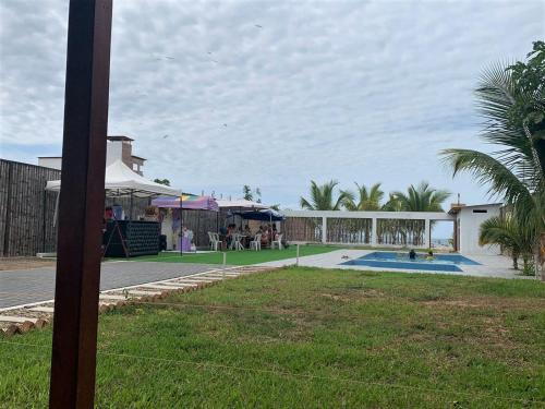 a yard with a swimming pool and a building with a table at Hospedaje & Casa Playa AURORA in Zorritos